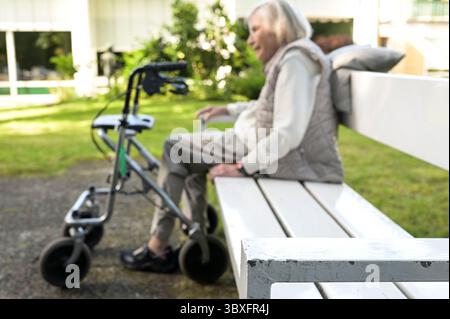 DEUTSCHLAND, Hamburg, alte Frau eines Pflegeheims im Garten mit Gehhilfe, Rollator Stockfoto