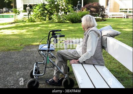 DEUTSCHLAND, Hamburg, alte Frau eines Pflegeheims im Garten mit Gehhilfe, Rollator Stockfoto