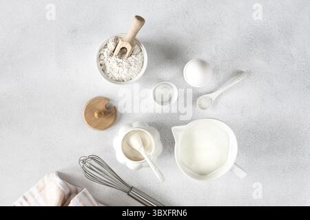 Lebensmittel, Backzutaten, Ei, Mehl, Zucker, Milch und Küchenwerkzeuge auf weißem Hintergrund mit Platz zum Kopieren Stockfoto