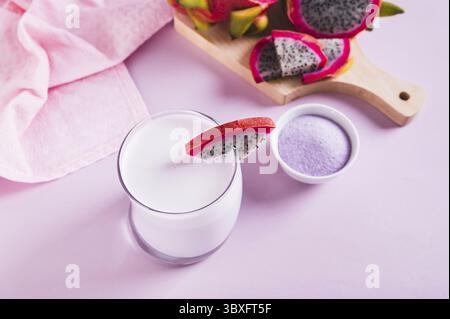 Essen, rosa Matcha Latte im Glas und Drachenfruchspulver in einer Schüssel auf dem Tisch Stockfoto