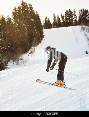 Junge Männer Skier Training in schwarzen Outfit Hose springt von Freestyle auf verschneiten Pisten Mid-Air Trick Wald Winter Freestyle Ride extremes Sportkonzept Stockfoto