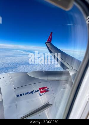 Oslo, Norwegen - 14. November 2023: Blick von einem Flugflügel der Norwegian Airlines über flauschigen Wolken, der das Design des Flugzeugs und das weitläufige Design unterstreicht Stockfoto