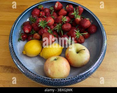 Close up Erdbeeren, Zitronen Äpfel, in antikem Glanz Schüssel die reife saftige Frucht Beeren Ernte frisch aus Bio-Landgarten Kleingarten Sommer Stockfoto