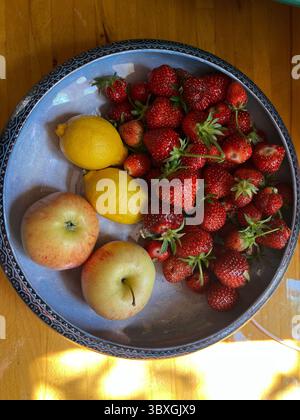 Close up Erdbeeren, Zitronen Äpfel, in antikem Glanz Schüssel die reife saftige Frucht Beeren Ernte frisch aus Bio-Landgarten Kleingarten Sommer Stockfoto