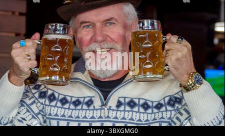 Ein älterer, grauhaariger, gutaussehender Mann in einer Bierbar ruht sich aus Stockfoto