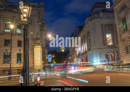 Blick auf die George Street, Wesminster bei Nacht in Richtung Big Ben mit leichten Wanderwegen Stockfoto