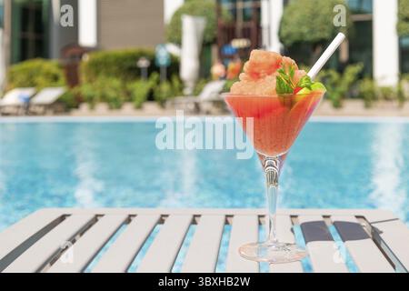 Frischer roter Cocktail mit Eis im Glas im Swimmingpool. Tropischer Saft bei Luxusurlauben. Konzept Sommerurlaub und Reisen Stockfoto
