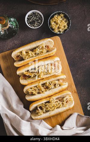 Essen, leckere Hot Dogs mit Rindfleischwurst und gebratenen Zwiebeln auf einem Brett oben und vertikaler Sicht Stockfoto