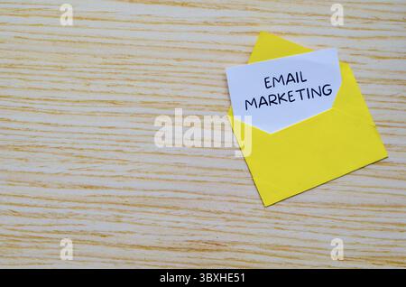 E-Mail-Marketing-Text auf weißem Notizblock in einem gelben Umschlag mit anpassbarem Platz für Text Stockfoto
