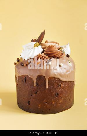 Osterkuchen - Russischer und ukrainischer traditioneller Kulich mit Süßigkeiten und Marschmalereien auf gelbem Hintergrund. Paska Osterbrot. Frohe Ostern. Stockfoto