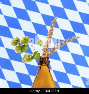 Bierflasche mit Hop Weizen Ast, weiße blaue bayerische Fahne Stockfoto