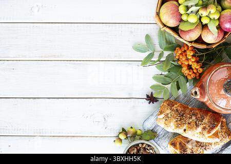 Essen, frisch gebackene Apfel- und Zimtrollen aus Blätterteig auf einem weißen Holztisch Stockfoto