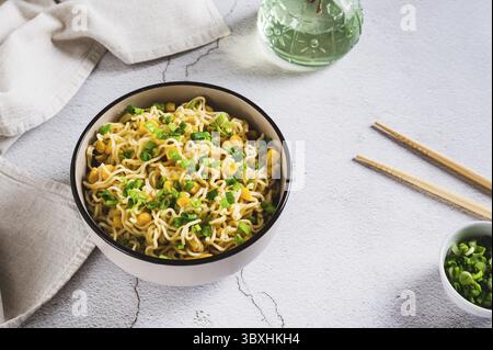 Essen, Eine Schüssel mit Instant-Nudeln und Gemüse auf dem Tisch Stockfoto