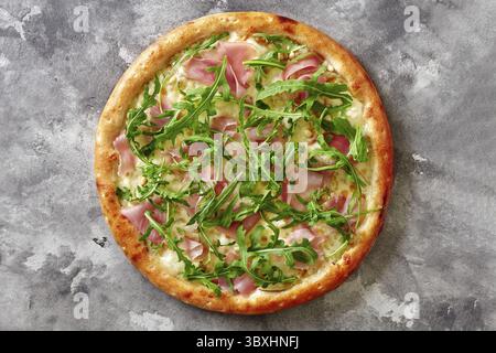 Pikante Pinoli-Pizza mit Käse- und Rahmsoße, Mozzarella, Prosciutto-Scheiben und Gorgonzola kombiniert mit reifen Birnen und leicht gerösteten Pinienkernen Stockfoto
