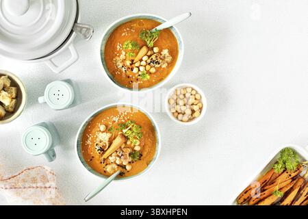 Speisen, vegetarische Herbstkürbis- und Karottensuppe mit Sahne, Samen und Koriander-Mikrogemüse Stockfoto