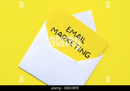 E-Mail-Marketingtext auf gelbem Notizblock in einem weißen Umschlag. Online-Konzept „Geld verdienen“ Stockfoto