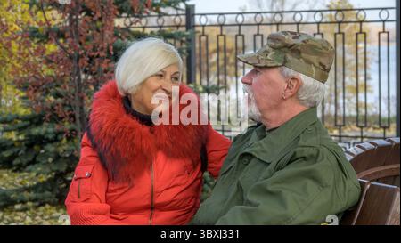 Porträt eines liebevollen älteren Ehepaares im Hintergrund des herbstlichen Stadtparks Stockfoto