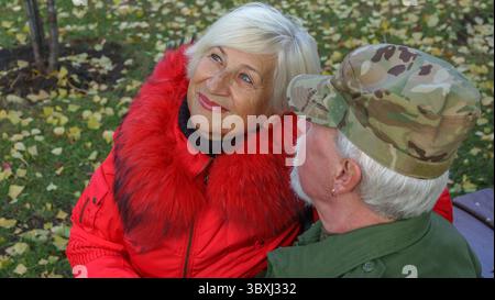 Porträt eines liebevollen älteren Ehepaares im Hintergrund des herbstlichen Stadtparks Stockfoto