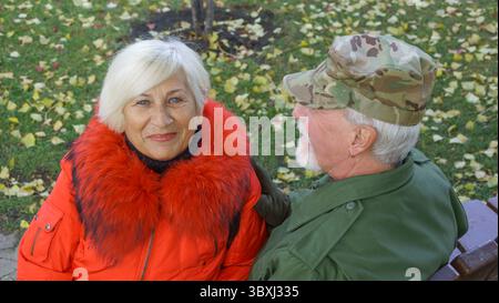 Porträt eines liebevollen älteren Ehepaares im Hintergrund des herbstlichen Stadtparks Stockfoto