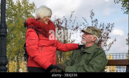 Porträt eines liebevollen älteren Ehepaares im Hintergrund des herbstlichen Stadtparks Stockfoto