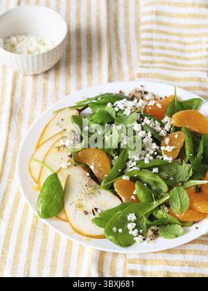 Salat aus Spinat und Quinoa mit Birnen, Orangen und Ricotta. Vorbereitung gesunder Mahlzeiten. Gerichte auf pflanzlicher Basis. Grünes Leben. Veganes Rezept. Styling von Lebensmitteln. Vegetarisch Stockfoto