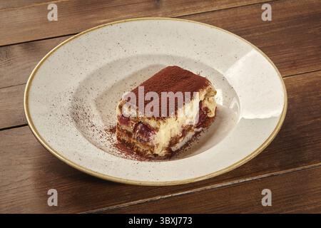 Genießen Sie ein Stück Tiramisu, ein klassisches italienisches Dessert mit Schichten von kaffeeingetränkten Marienfinger, Mascarponescreme und Kakaopulver Stockfoto