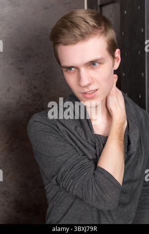 Porträt eines jungen Mannes auf einem dunklen Hintergrund aus Metall Stockfoto