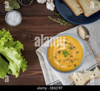 Vegetarisches Pupmkin Creme Suppe Püree, auf dunkelbraunem Holztisch, Draufsicht, Nahaufnahme Stockfoto