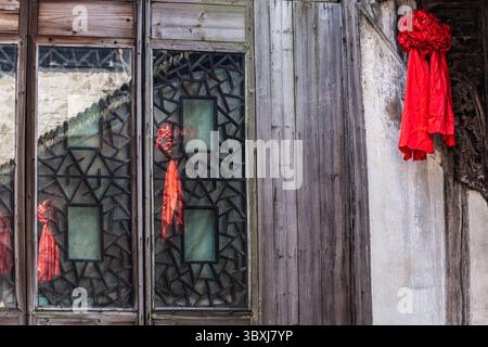 18. Mai 2013, Wuzhen, Provinz Zhejiang, China: Rote Bänder spiegeln sich im Fenster einer alten Wohnung in der Stadt Wuzhen, China. (Kreditbild: © Jon G. Fuller/VW Pics via ZUMA Press Wire) Stockfoto