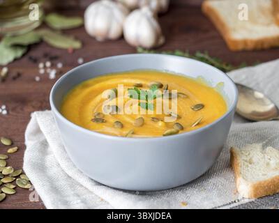 Vegetarisches Pupmkin Creme Suppe Püree, auf dunkelbraunem Holztisch, Seitenansicht, Nahaufnahme Stockfoto