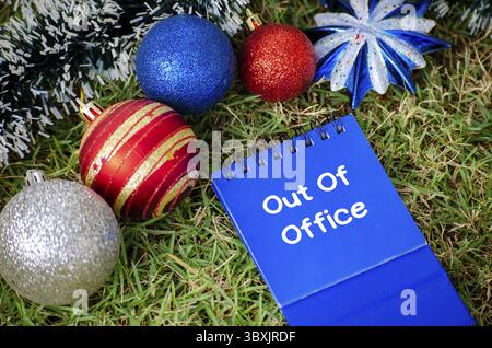 Draufsicht des Abwesenheitstextes auf blauem Notizblock mit weihnachtlichem Hintergrund. Weihnachtszeit und Happy Holiday Konzept Stockfoto