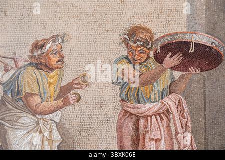 NEAPEL, ITALIEN – 26. JUNI 2025: Mosaikdetail mit Straßenmusikern aus Pompeji im Archäologischen Museum von Neapel, in dem Roman d Stockfoto