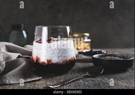 Essen, Chia Pudding mit Joghurt und Johannisbeermarmelade in einem Glas auf dem Tisch Stockfoto