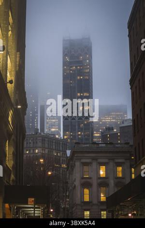 Klassischer Nachtblick von Downtown Manhattan Street in New York inmitten von Gebäuden Stockfoto
