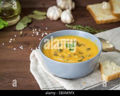 Vegetarisches Pupmkin Creme Suppe Püree, auf dunkelbraunem Holztisch, Seitenansicht, Nahaufnahme Stockfoto