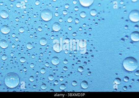 Nahaufnahme von Wassertröpfchen auf blauem Deckgrund. Wassertröpfchenkonzept Stockfoto
