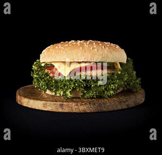 Köstliche frische klassische Burger auf Holz Schneidebrett isoliert auf Schwarzer Hintergrund Stockfoto