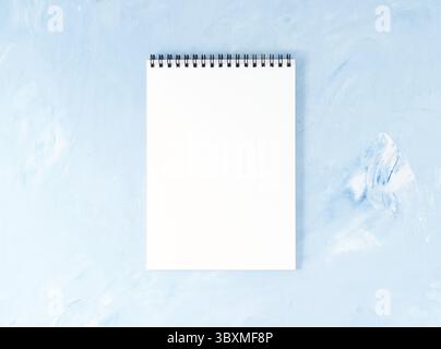 Blick von oben auf die modernen hellen blauen Desktop im Büro mit einem Notizblock. Bis Mock, leeren Raum Stockfoto