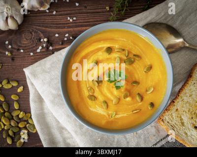 Vegetarisches Pupmkin Creme Suppe Püree, auf dunkelbraunem Holztisch, Draufsicht, Nahaufnahme Stockfoto