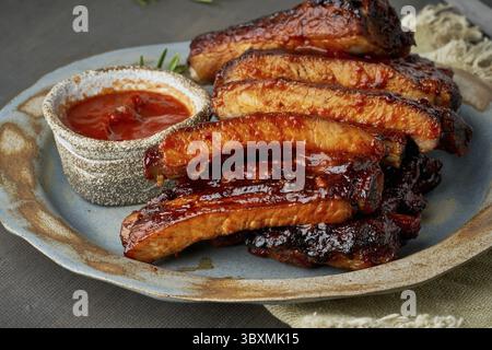 Keto-Essen, scharfe Grillrippchen. Langsames Kochen. Gebratenes Schweinefleisch mit roter Sauce. Asiatische Küche, Koreanisch. Seitenansicht, Nahaufnahme Stockfoto