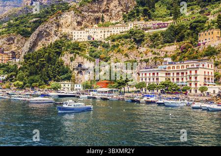 Blick auf die kleine Oase des Amalfi Dorfes mit winzigem Strand und farbenfrohen Häusern auf Felsen. Amalfiküste, Salerno, Kampanien, Italien Stockfoto