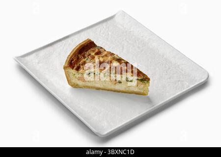 Herzhafte Quiche-Scheibe mit Lachs, Brokkoli und einer cremigen Füllung, serviert auf einem eleganten weißen Teller Stockfoto