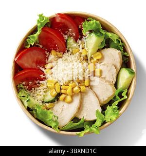 Frischer Salat mit grünem Salat, Stückchen reifer Tomaten, Gurken, gebackenem Hähnchenfilet, Mais und geriebenem Käse serviert in einer Schüssel aus Pappe, Blick von oben Stockfoto