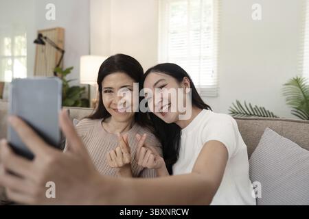 Tochter Erwachsene nimmt Selfie mit Mobiltelefon mit älterer Mutter zu Hause Stockfoto