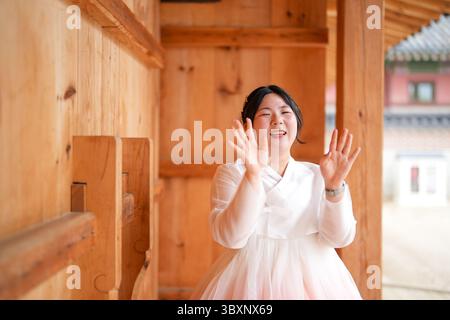 Im Juni in Seoul öffnen zwei koreanische Frauen in ihren Zwanzigern gemeinsam ein traditionelles Holztor im Gyeongbokgung Palace, in dem sie das charmante pi tragen Stockfoto