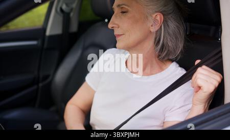 Erfolgreiche kaukasische lächelnde ältere Geschäftsfrau reife Geschäftsfrau Autofahrer Autohalter Mietwagenkunde sitzen in einem neuen Fahrzeug Stockfoto