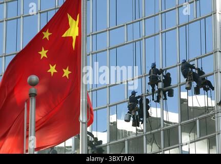 17. Januar 2007, PEKING, CHINA: Chinesische Fensterputzer sitzen auf Holzbrettern, die an Seilen befestigt sind, während sie am 17. Januar 2007 das Äußere des Grand Hyatt Hotels in der Innenstadt von Peking, China, waschen. (Bild: © Stephen Shaver/ZUMA Press Wire) Stockfoto