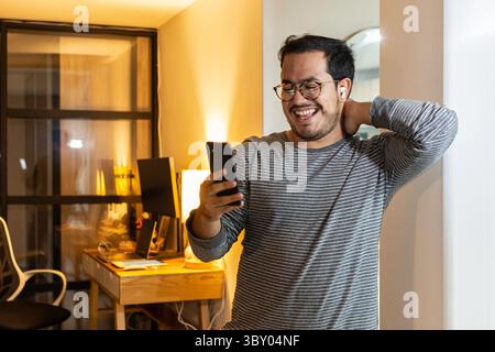 Besorgter Unternehmer, der schlechte Nachrichten am Telefon im Home Office liest Stockfoto