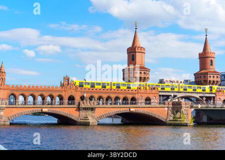 Berlin, Deutschland - 30. Mai 2025: Berühmte Oberbaumbrücke in Berlin, mit einer gelben U-Bahn, die den Fluss mit blauem Himmel und weißem cl überquert Stockfoto