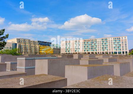 Berlin, Deutschland - 31. Mai 2025: Holocaust-Gedenkstätte in Berlin mit grauen Betonplatten unter hellblauem Himmel, umgeben von modernen Gebäuden und Stockfoto